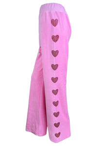 pink velour trackpants with red rhinestone hearts down the arms and legs.  Velour sweatpants with custom rhinestones.